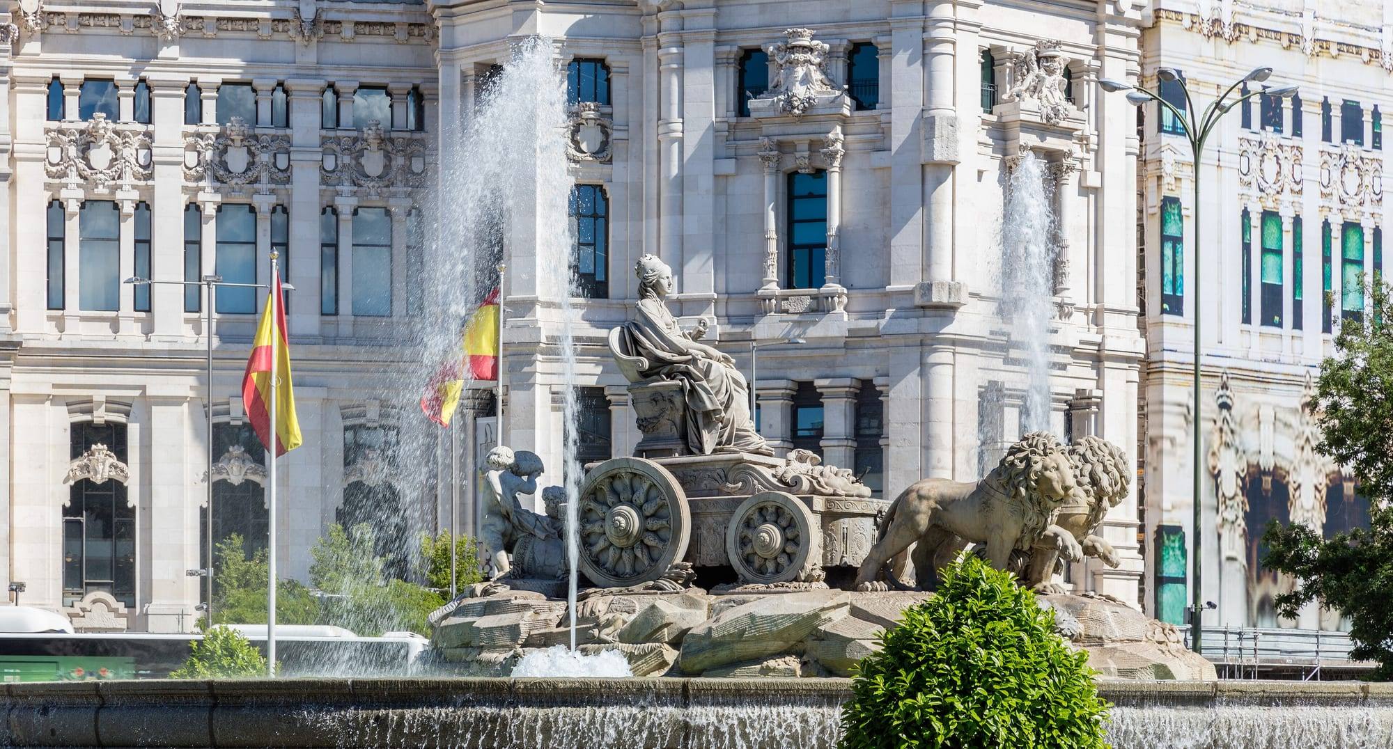 The Cibeles fountain with the goddess on her lion-drawn chariot, in front of the white Palacio de Cibeles (city hall)